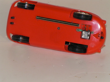 UNDERSIDE OF THE 1/24TH SCALE JAG D SHOWING THE 3 & 1/2 VOLT MOTOR & RAIL LIKE GUIDE.FROM THE SET