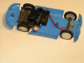 INTERIOR OF THE 1/32 SCALE JAG D. GEARS & A PULLEY FOR BELT DRIVE. STRANGE BLACK MOTOR.