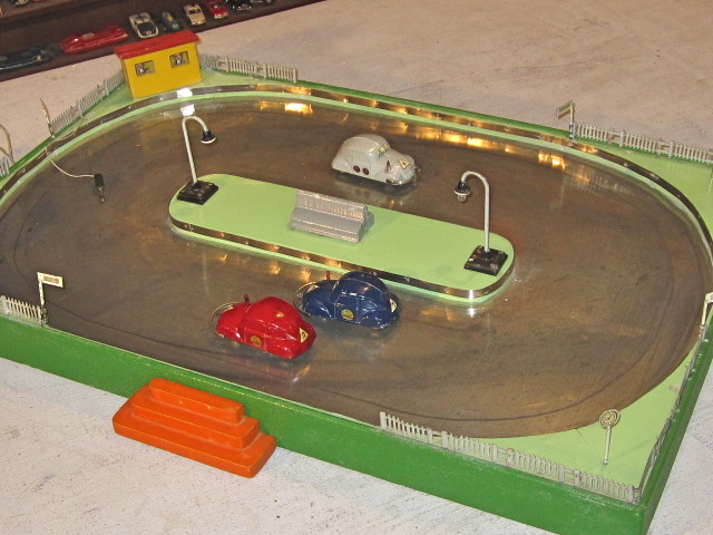 PARTLY ASSEMBLED SET WITH OUT THE TOP SHOWING THE 2 WORKING LIGHTS AND THE METAL BASE FOR CONDUCTING ELECTRICITY TO THE FRONT WHEELS.