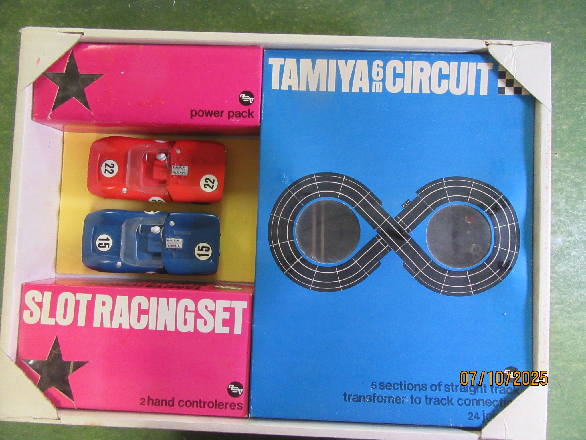 CLOSE UP OF THE TOP TRAY SHOWING THE 2  1/24TH SCALE LOLA T70 CARS .TOP TRAY ALSO CONTAINS TRACK,2 CONTROLLERS & A TRANSFORMER