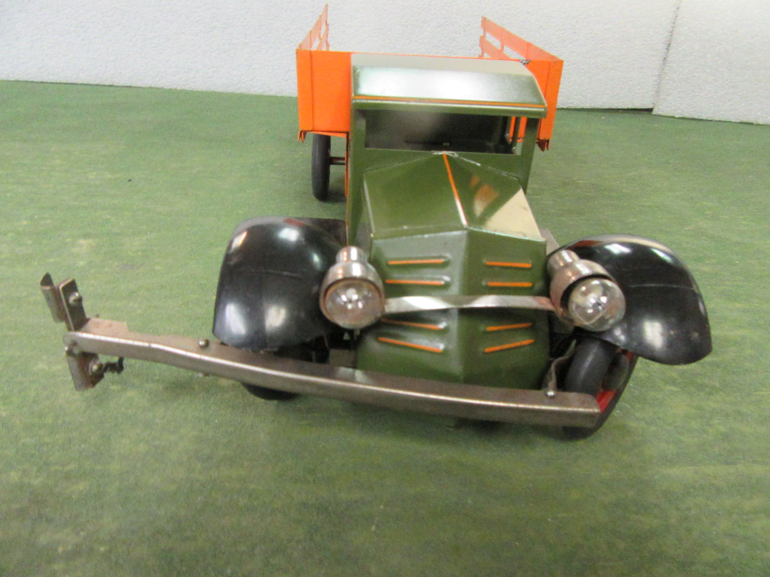 FRONT VIEW OF THE STAKE BED TRUCK SHOWING THE HEADLIGHTS.