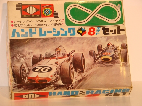 VERY TINY SET WHERE YOU HOLD THE SET IN YOUR HANDS AND MOVE THE SET SO THE CARS ROLL IN THE SLOTS